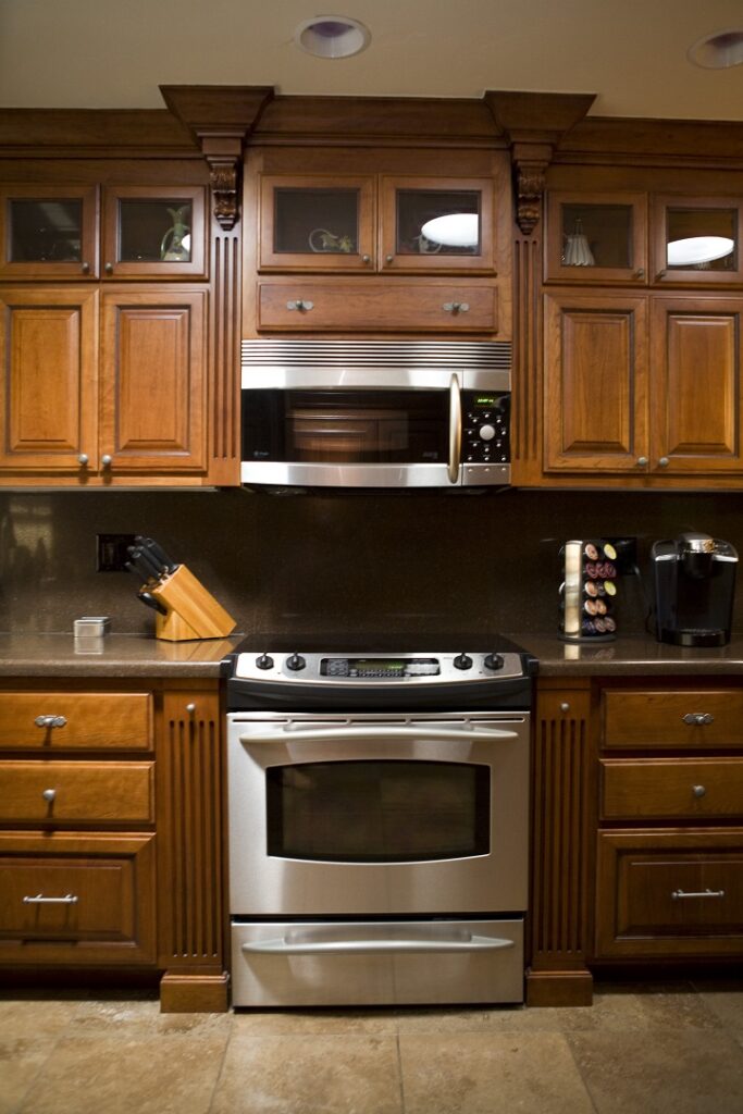 Fluted spice towers flank cooktop in amazing cherry kitchen