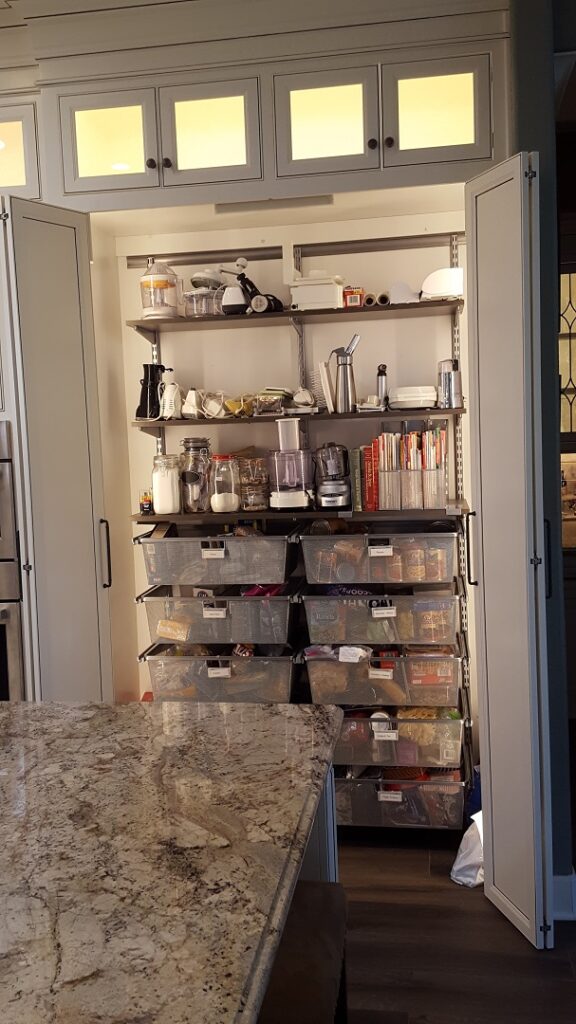 custom bifold cabinet doors on large built in pantry. Hafele LED lights automatically turn on and illuminate the entire custom pantry organizer.